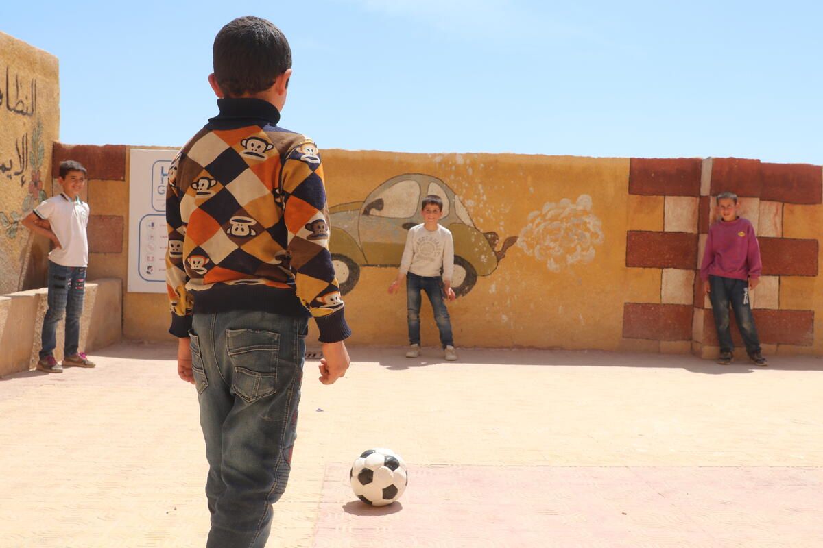 Kareem* playing football with his friends at the space