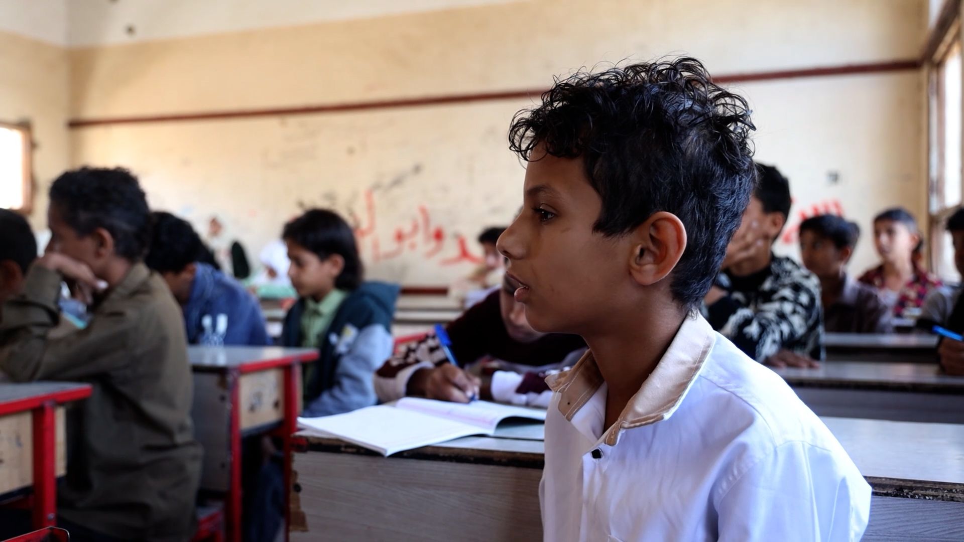 Essam*, 12, attending school in a semi-destroyed building that's contaminated with landmines in Taiz, Yemen.