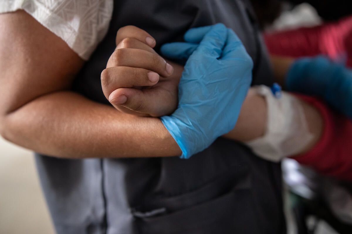 Save the Children's paediatric nurse, comforts Solave* (13) who lost her right leg when a bomb dropped on the house where she was sheltering in Gaza. Photo: Sacha Myers / Save the Children